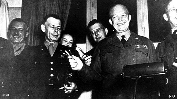 General Dwight D. Eisenhower faz o V de vitória com duas canetas em Reims, em 7 de maio de 1945