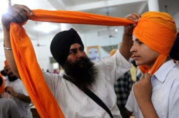 A Sikh boy has a turban tied over his he