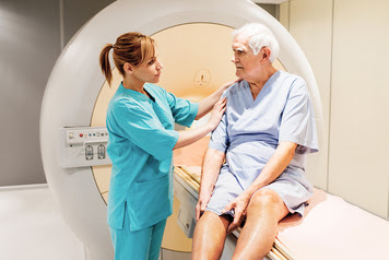 Female nurse preparing a mature patient for an MRI Scan