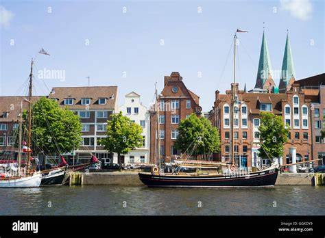 A view of LÃ¼becks harbor with historic ships and a backdrop of the city