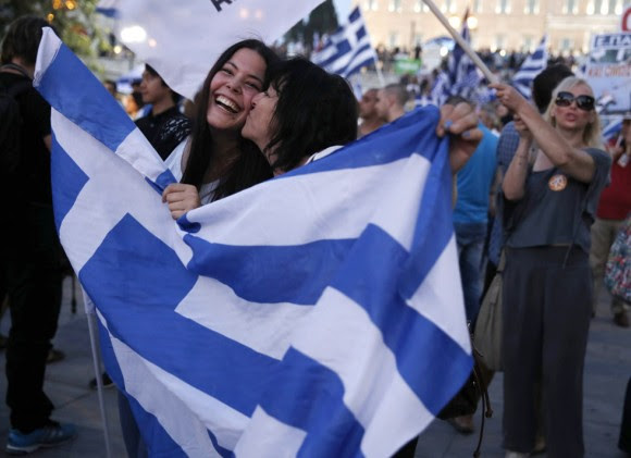 El presidente del Gobierno español, Mariano Rajoy, ha convocado para mañana a los miembros de la Comisión Delegada de Asuntos Económicos para analizar el resultado del referéndum griego. En la imagen, dos mujeres se besan tras la victoria del 'no' en el referéndum griego. Foto: PETROS GIANNAKOURIS (AP)