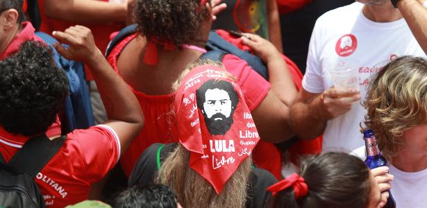 9.nov.2019 - Mulher usa lenço na cabeça com estampa do rosto do ex-presidente Lula