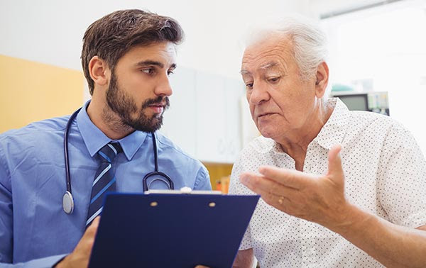 older male patient consulting his younger male doctor.