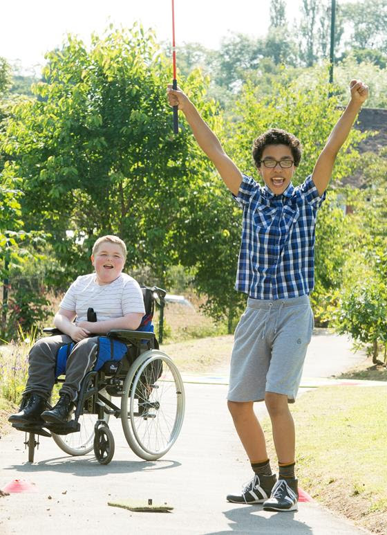 Two young men playing adapted golf outside