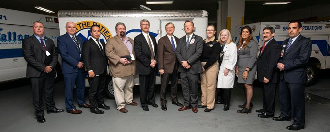 Photo of ASPR leaders and MGH Leaders standing in front of ambulance
