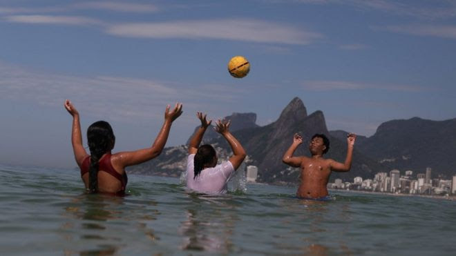 adolescentes jogam bola dentro do mar no Rio de Janeiro