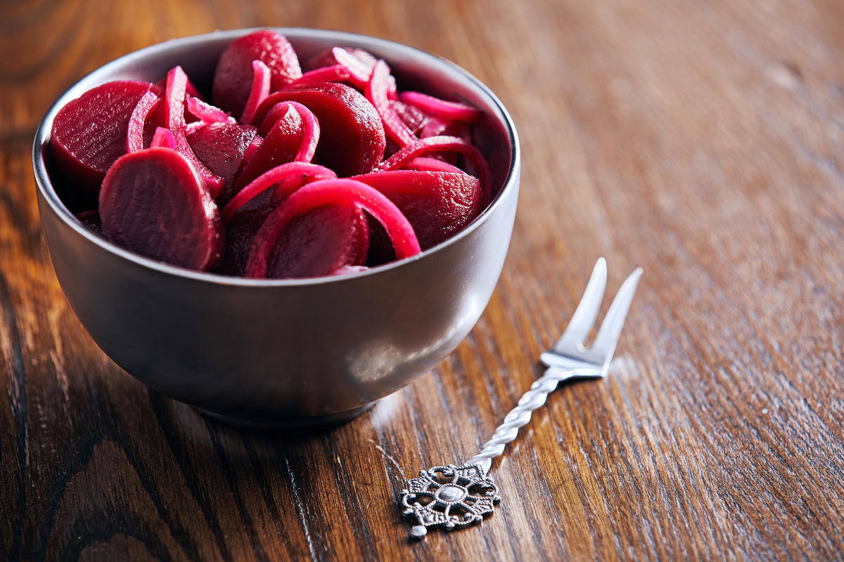 Beets improve blood flow which leads to better exercise Pickled Beets in a bowl with a fork next to it