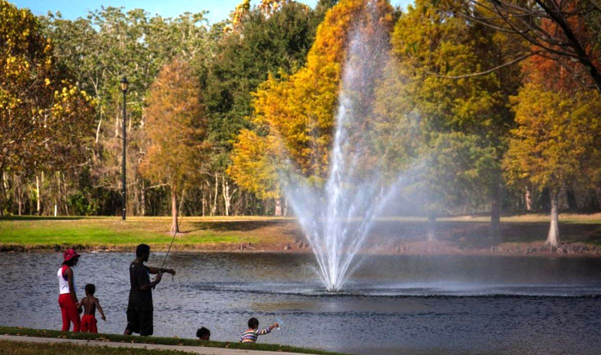 An autum day at a park with a lake and fountain