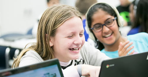 Two female students looking at a laptop.