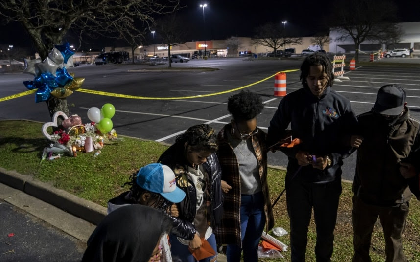 Anti-gun violence activists pray outside the Walmart in Chesapeake.