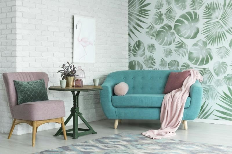 A blue couch and pink chair in a room Description automatically generated