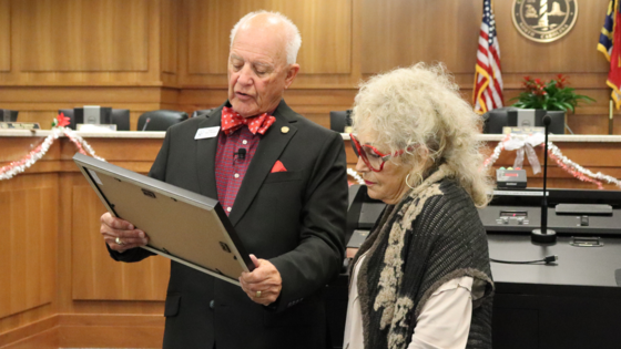 Image of Bob Woodard reading the Certificate of Achievement to Carol Ann Angelo.