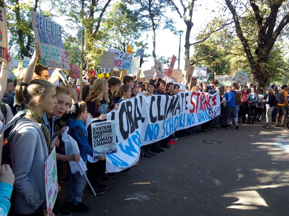 Schoolchildren at the front of a march holding a large, hand-painted banner which reads 'Global Climate Strike. No Work! No School! No Uni!'