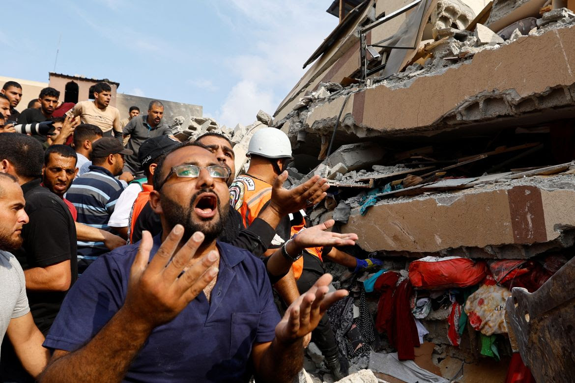 Palestinians react as they search through the rubble of a house destroyed in Israeli attacks in Khan Younis in the southern Gaza Strip
