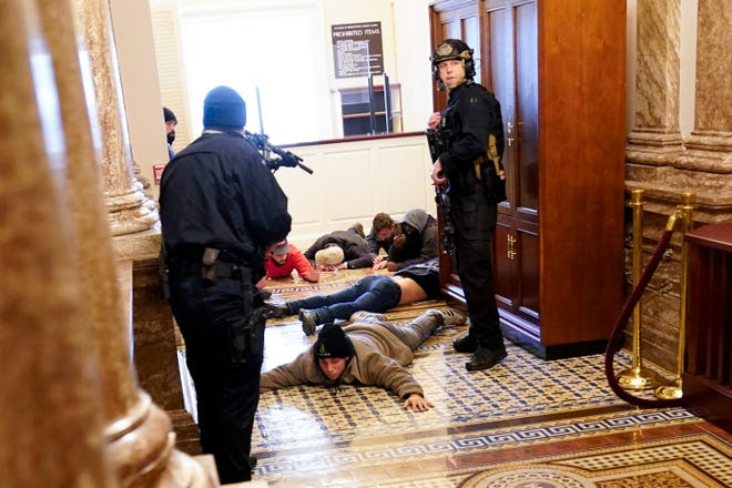 U.S. Capitol Police hold rioters at gunpoint near the House Chamber.