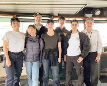 Group of people in the pilothouse of a ferry