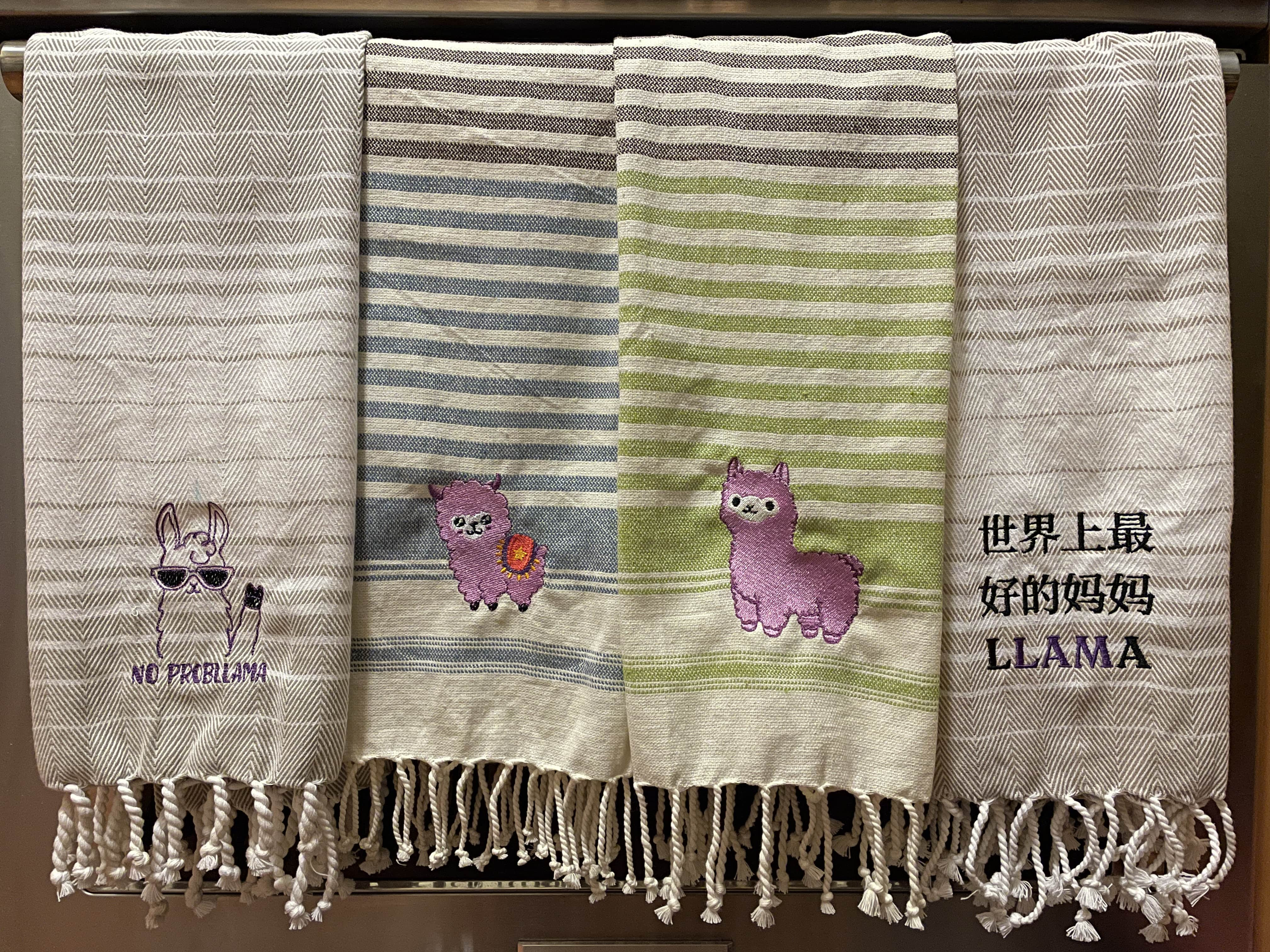 Four kitchen towels that are embroidered