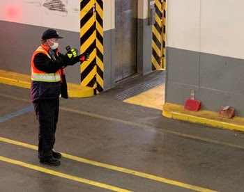 Photo of crewmember wearing a face covering while directing traffic aboard a ferry