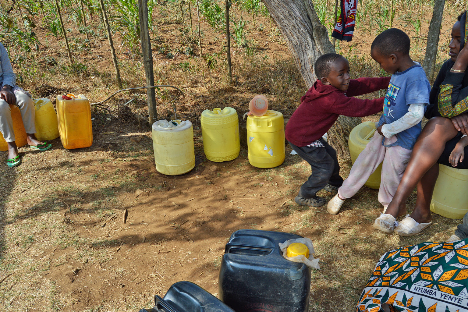 The Karanja children play as their mother waits for her turn to fetch water.