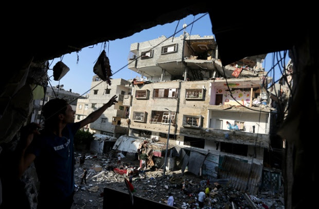 Palestinians inspect the rubble of a house after it was hit by an Israeli missile strike in Gaza City.