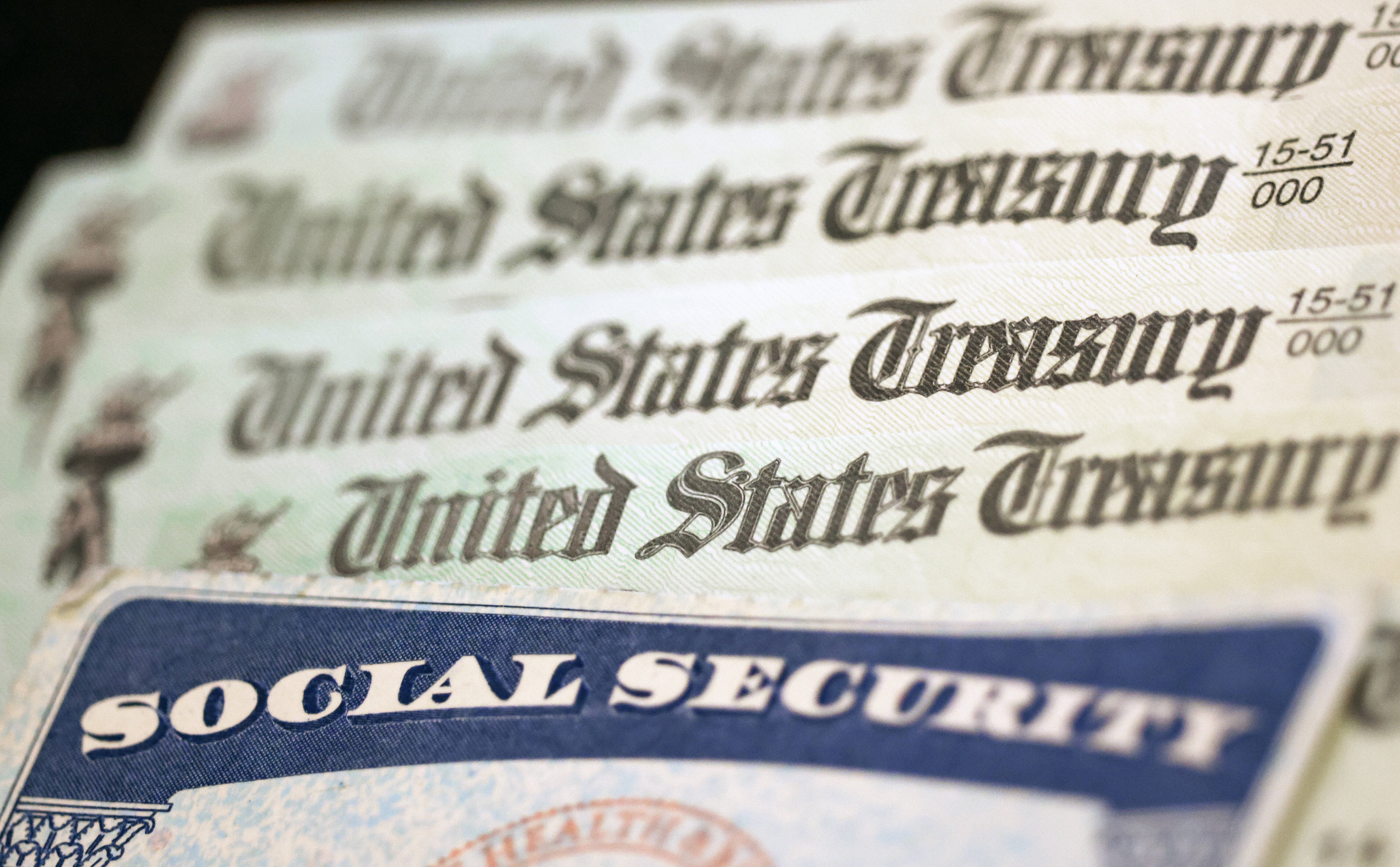 A Social Security card sits alongside checks from the U.S. Treasury. The Social Security Administration has given retirement statements a makeover. They're now shorter — streamlined down to two pages from the previous four — and, thankfully, better written.