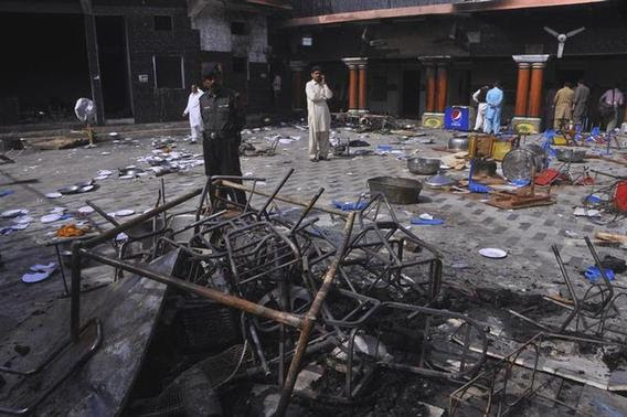 A security official and members of the Hindu community stand inside a temple that was attacked on Saturday night, in Larkana, southern Pakistan's Sindh province, March 16, 2014. REUTERS-Faheem Soormro