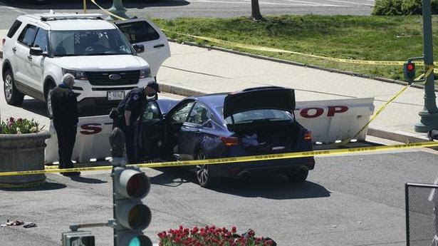 U.S. Capitol Police officers stand near a car that crashed into a barrier on Capitol Hill in Washington, on Friday, April 2, 2021.