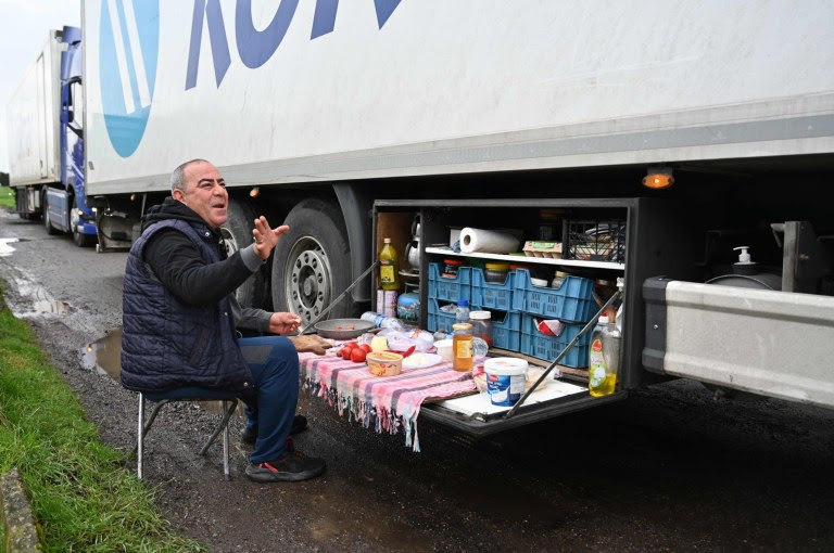 A Turkish long-haul truck driver eats his breakfast at a truck stop off the M20 motorway which leads to the Port of Dover, near Ashford in Kent, south east England on December 22, 2020, as he queues unable to continue his journey after France closed its borders to accompanied freight arriving from the UK due to the rapid spread of a more-infectious new coronavirus strain. - Britain sought to sound a note of calm saying they were working as fast as possible to unblock trade across the Channel after France shut its borders to UK hauliers in a bid to contain a new variant of the coronavirus. (Photo by JUSTIN TALLIS / AFP) (Photo by JUSTIN TALLIS/AFP via Getty Images)