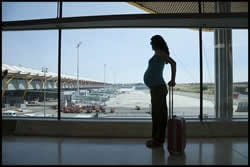 The figure above is a photograph showing a pregnant traveler at an airport. 