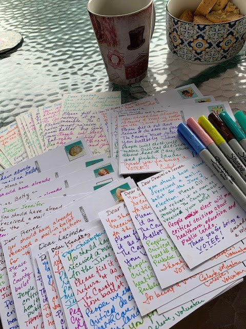 Postcards and postcarding supplies on a table.