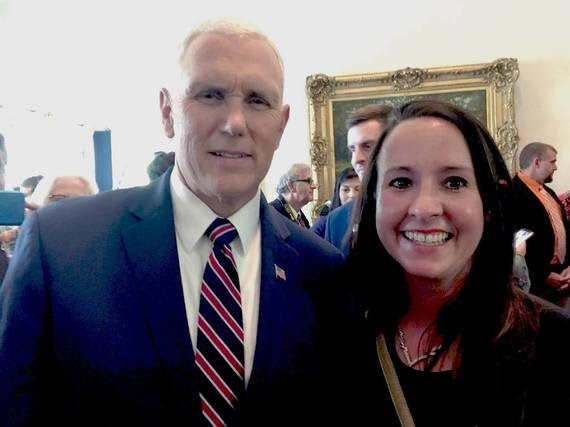 Sara Reed poses for a picture with Vice President Mike Pence in a crowded room in the White House.