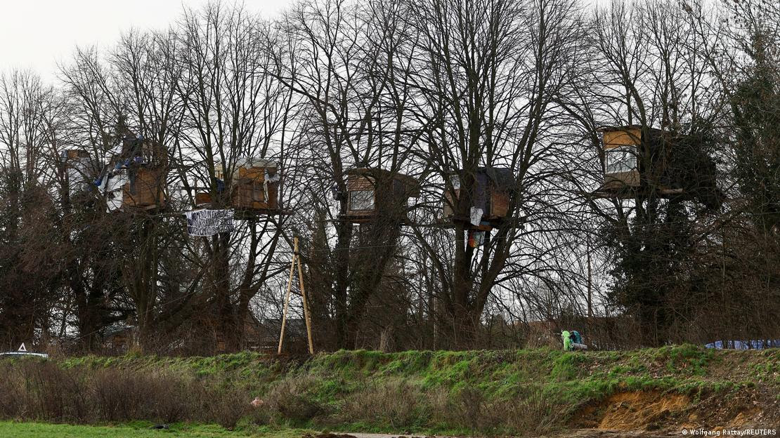 Fileira de árvores com casas construídas por manifestantes desde 2020 em Lützerath, no oeste rural da Alemanha.