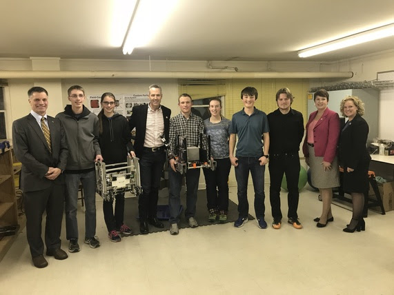 State Treasurer Mark Gordon, Secretary of State Ed Murray, State Auditor Cynthia Cloud, and State Superintendent Jillian Balow stand with high school students holding their robots.