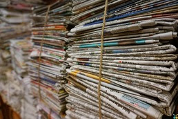 Two stacks of newspapers binded with string