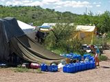 In this Thursday, Aug. 5, 2010, file photo, No More Deaths volunteer Katie Maloney checks water jugs at the group&#39;s camp before heading out to supply water stations for illegal immigrants near Arivaca, Ariz., about 13 miles north of Mexico. (AP Photo/Amanda Lee Myers, File)