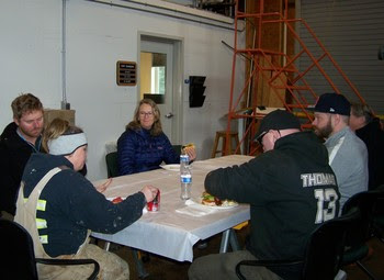 Several people sitting at a table eating food