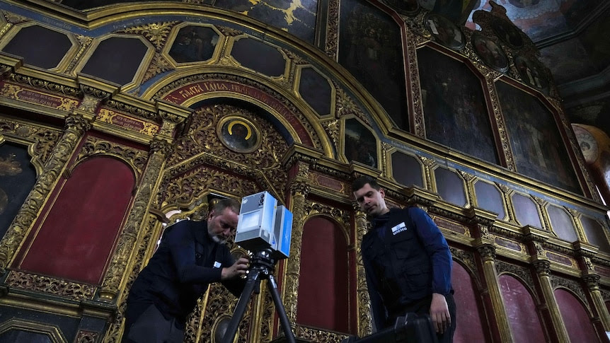 Volunteers setting up a laser imager to scan the All Saints Church in Kyiv.