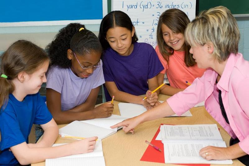 teacher helping middle school students with class work