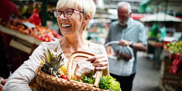 Woman at market with basket of veges