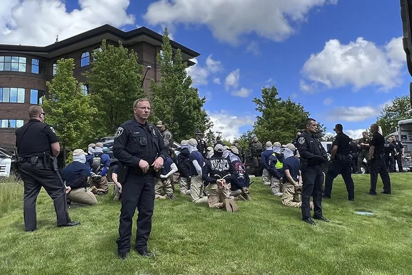 Police guard members of a white supremacist group after their arrests Saturday in Coeur d'Alene, Idaho.