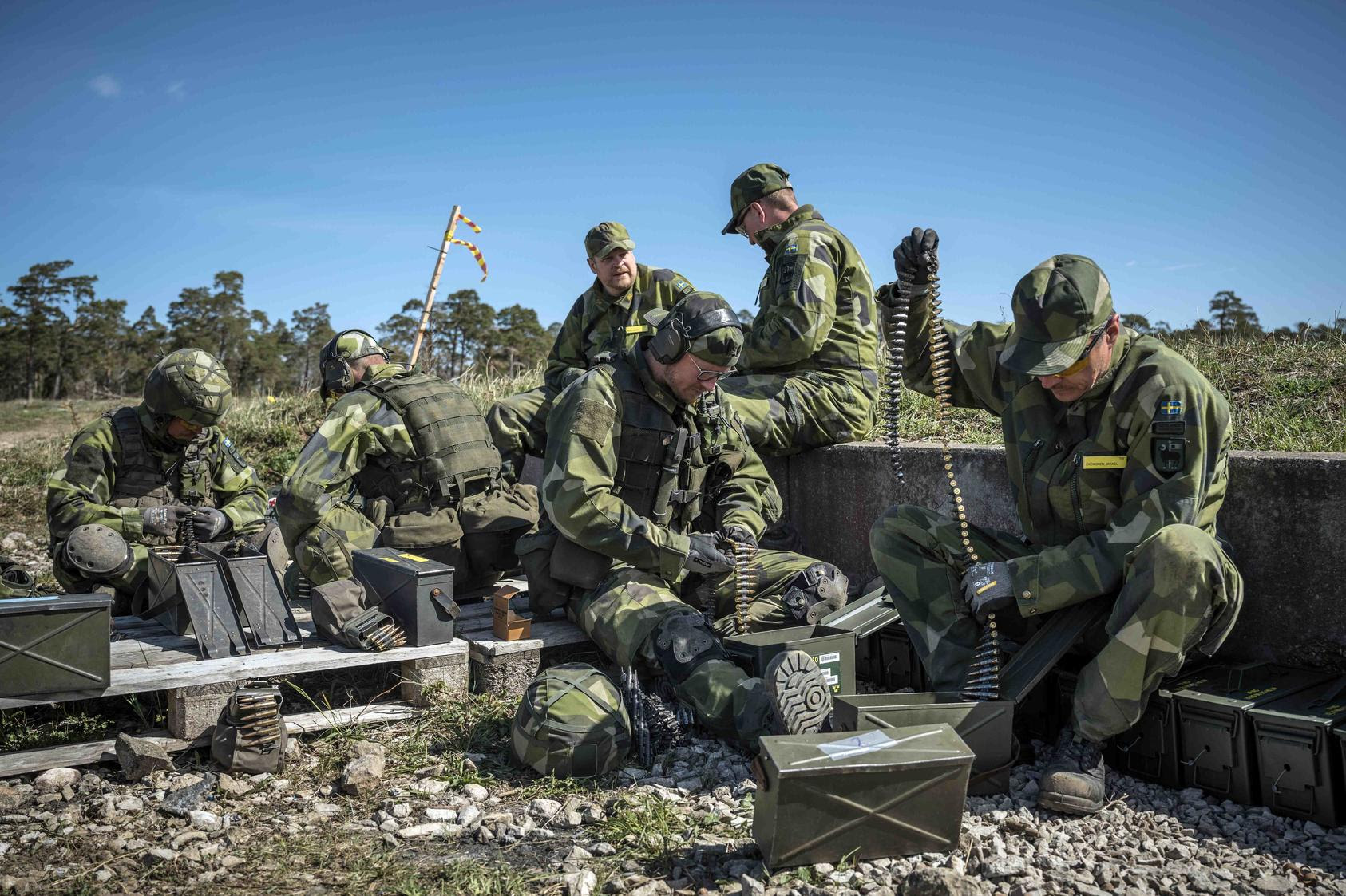 Troops with the Gotland regiment of the Swedish Army reload their machine guns during target practice on Gotland Island, Sweden, on May 11, 2022. (Sergey Ponomarev/The New York Times)