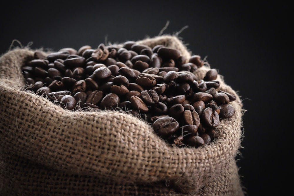 photographie de mise au point peu profonde de grains de café dans un sac