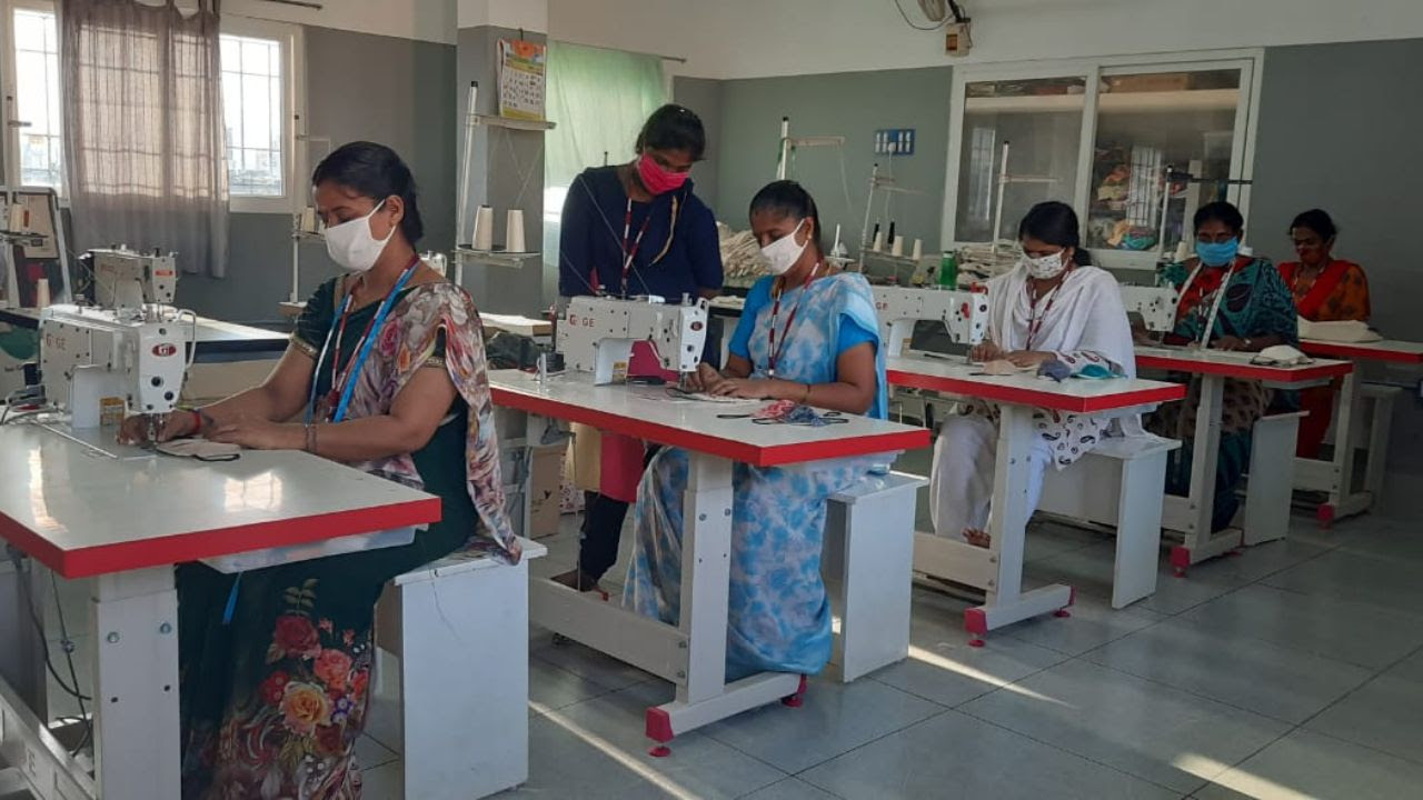 artisans wearing face masks, shown working in sewing centre