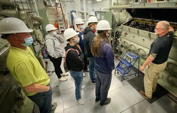 Several people in the engine room of a ferry