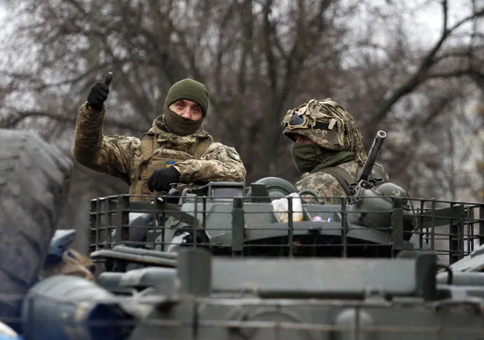 A Ukrainian serviceman gives a thumb up riding atop a military vehicle before an attack in Lugansk region on February 26, 2022. - Russia on February 26 ordered its troops to advance in Ukraine 