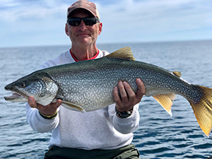 Angler holding a lake trout 