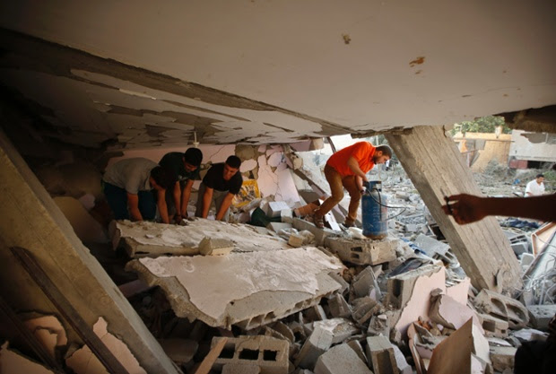 People search for their belongings in the rubble of a house destroyed in the northern Gaza Strip.