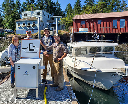 Image of new pumpout facility on Shaw Island with Shaw Island General Store owners Terri and Steve Mason and staff Nick Bure and Johnathan Hogue. 