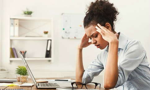 Woman experiencing a headache at work