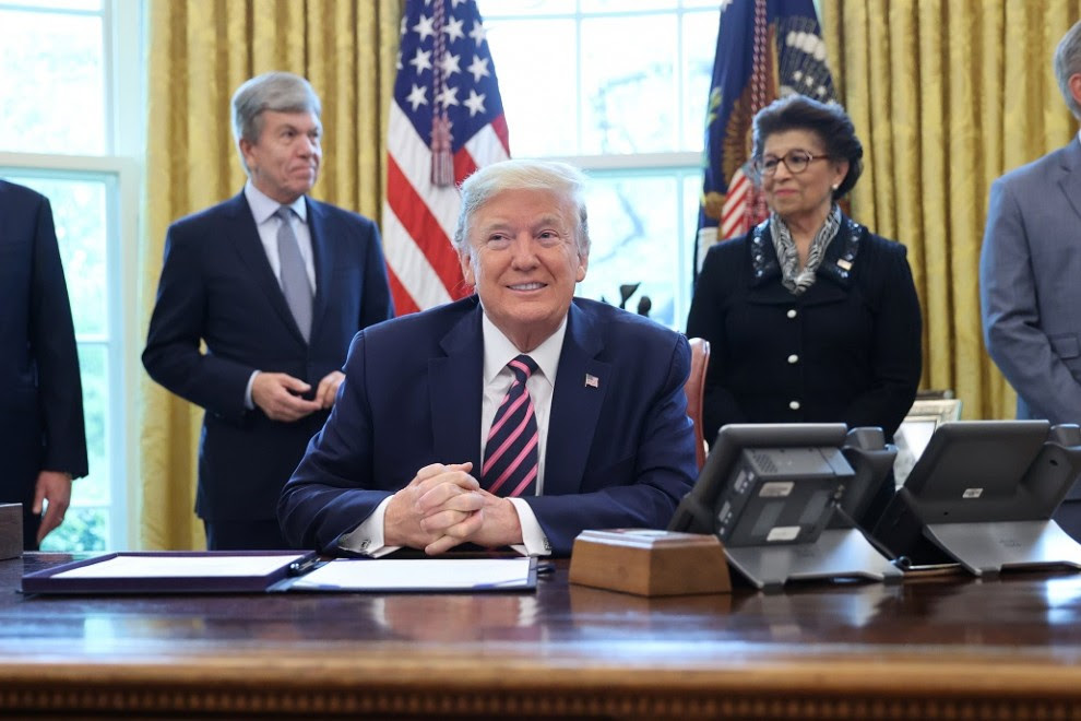 El presidente de los Estados Unidos, Donald Trump, sonríe, flanqueado por el secretario del Tesoro Steven Mnuchin, el senador Roy Blunt, la reponsable de la Oficina para las Pequeñas Empresas, Jovita Carranza y el líder de la minoría de la Cámara Kevin Mc